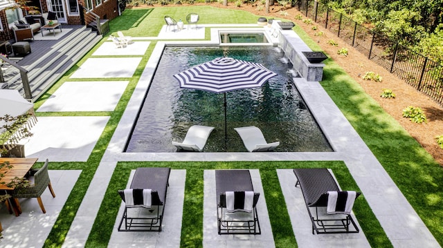 outdoor pool featuring a yard, a patio, an in ground hot tub, and a fenced backyard