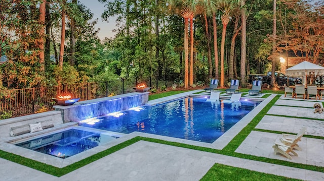 view of swimming pool with an in ground hot tub, a fenced backyard, a fenced in pool, and a patio