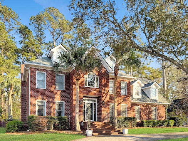 view of front of property featuring a front yard and brick siding