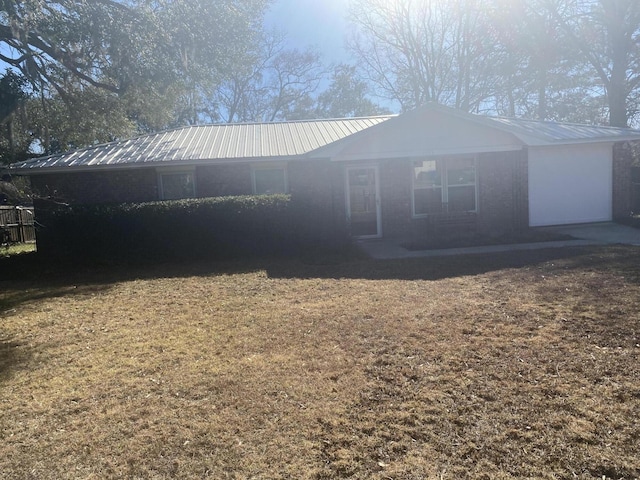 exterior space featuring metal roof and a lawn