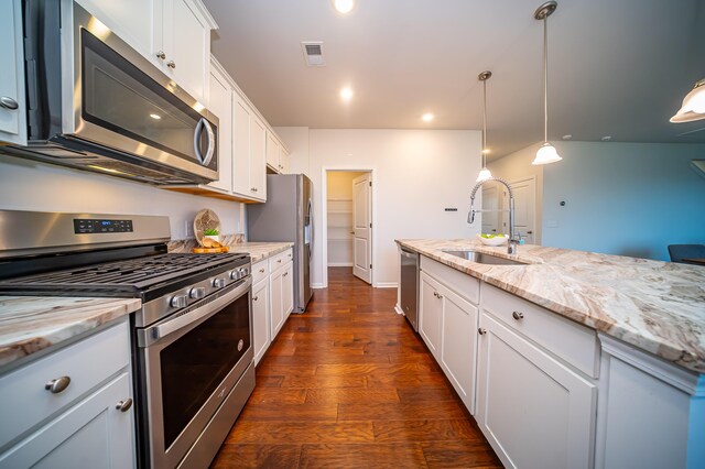 kitchen featuring dark hardwood / wood-style floors, stainless steel appliances, light stone countertops, and white cabinetry