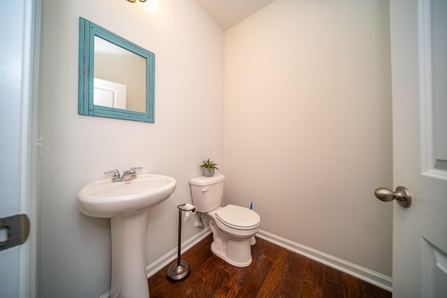 bathroom with wood-type flooring, toilet, and sink