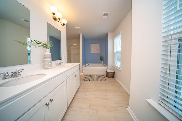 bathroom featuring a tub, dual vanity, and tile patterned flooring