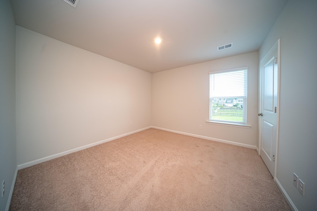 unfurnished room featuring light carpet