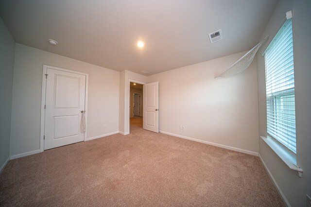 unfurnished bedroom with light colored carpet