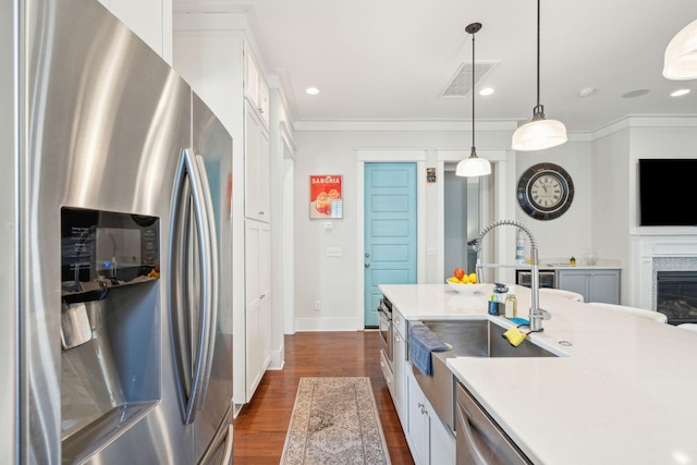 kitchen with stainless steel appliances, a sink, visible vents, white cabinetry, and dark wood finished floors