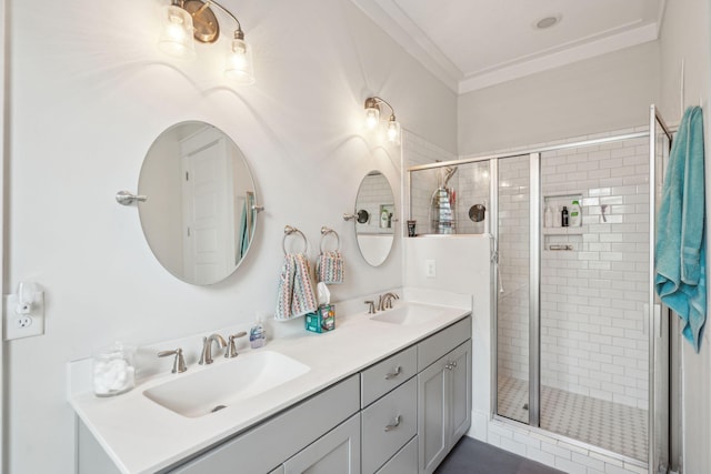 full bath with ornamental molding, a stall shower, and a sink