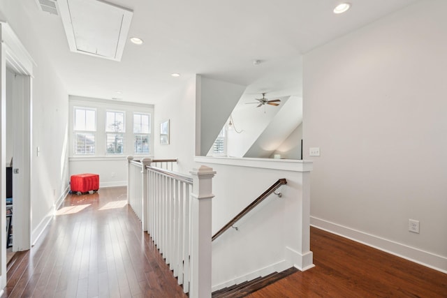 hallway featuring attic access, baseboards, dark wood-type flooring, an upstairs landing, and recessed lighting