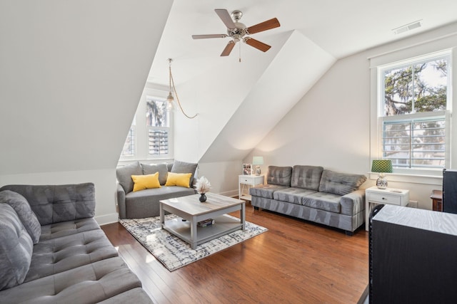 living area featuring plenty of natural light, visible vents, vaulted ceiling, and hardwood / wood-style floors