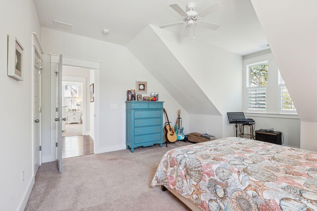 carpeted bedroom featuring ceiling fan, lofted ceiling, visible vents, and baseboards