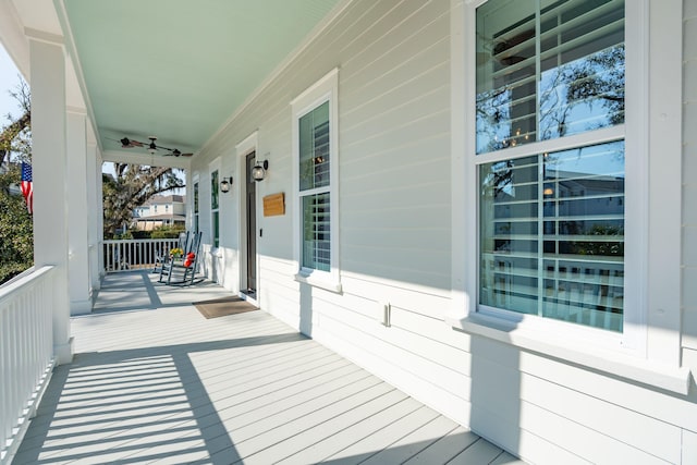 wooden deck featuring a porch and a ceiling fan