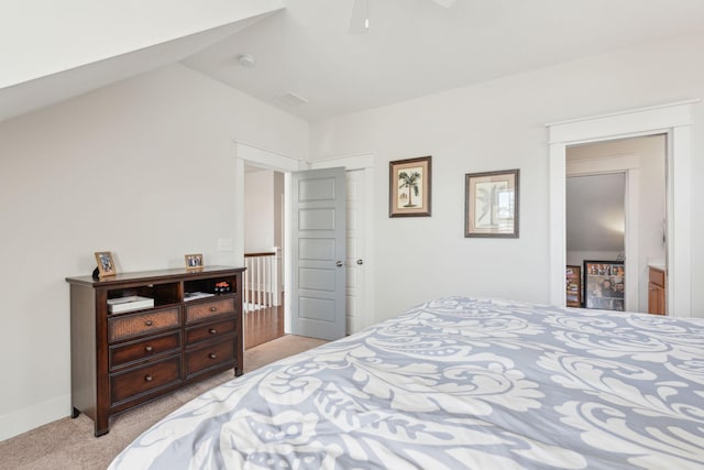 bedroom featuring light carpet, lofted ceiling, and baseboards