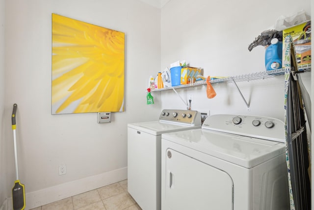 laundry room featuring washer and dryer, laundry area, light tile patterned flooring, and baseboards