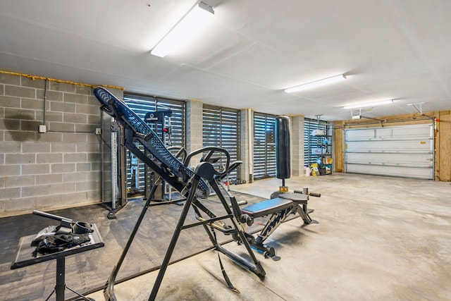 exercise room featuring a garage and concrete block wall