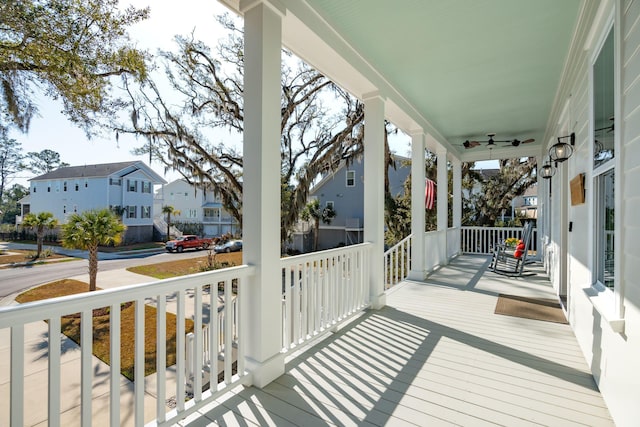 deck with ceiling fan, a porch, and a residential view