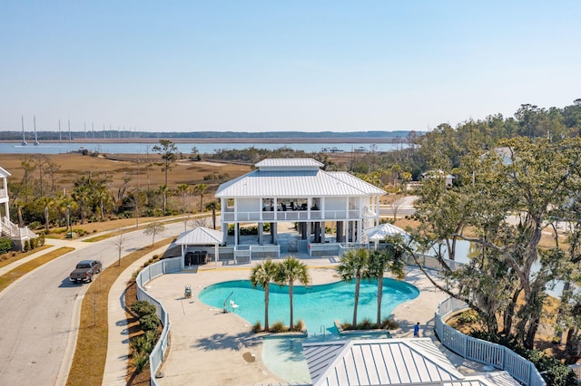 community pool with a water view, fence, a gazebo, and a patio