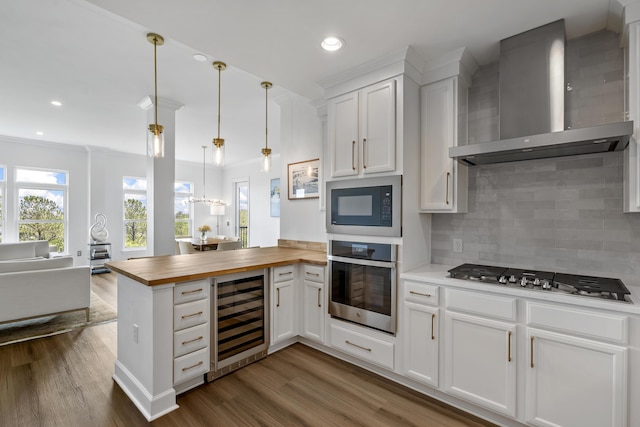 145 Pier View St Unit 407, Charleston, SC 29492 - kitchen featuring stainless steel appliances, wine cooler, wall chimney exhaust hood, butcher block counters, and a peninsula