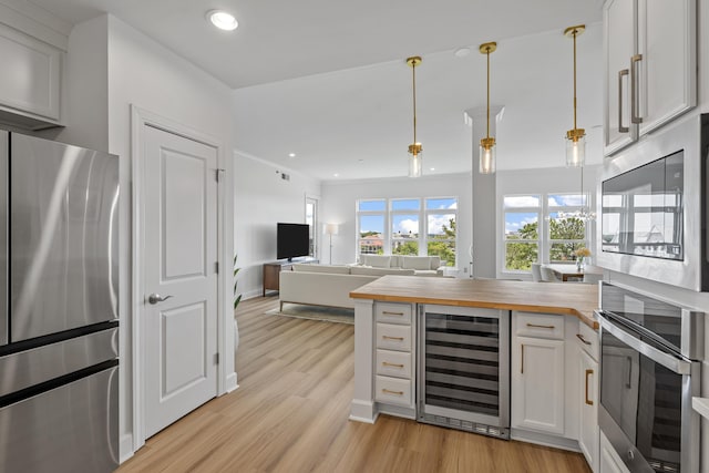 145 Pier View St Unit 407, Charleston, SC 29492 - kitchen featuring appliances with stainless steel finishes, beverage cooler, wood counters, light wood-style floors, and white cabinets