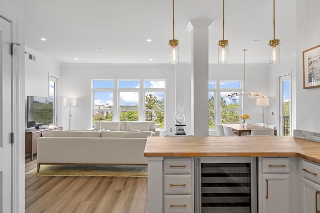 145 Pier View St Unit 407, Charleston, SC 29492 - kitchen with wood counters, beverage cooler, open floor plan, crown molding, and wood finished floors