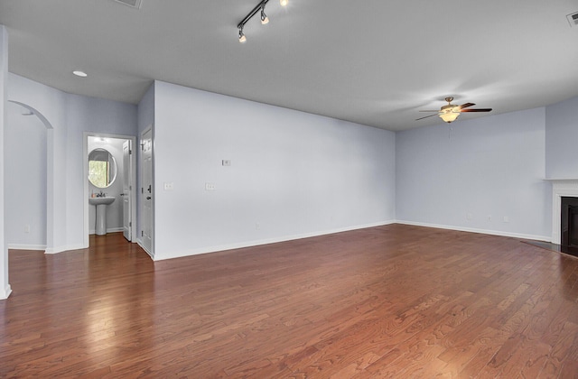 123 Blackwater Way, Moncks Corner, SC 29461 - unfurnished living room with a ceiling fan, a glass covered fireplace, dark wood finished floors, and arched walkways