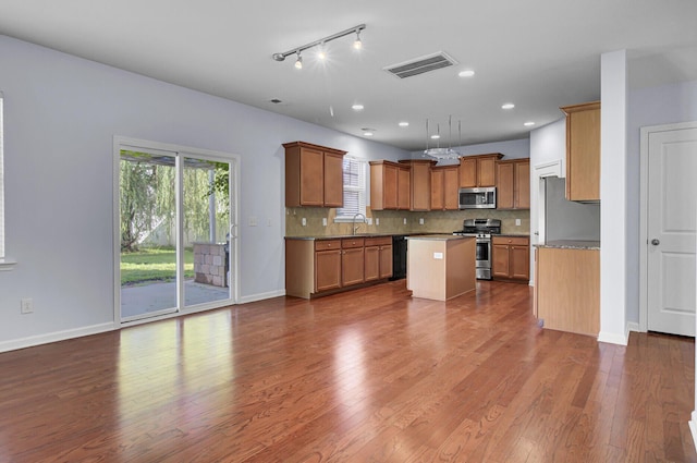 123 Blackwater Way, Moncks Corner, SC 29461 - kitchen featuring appliances with stainless steel finishes, plenty of natural light, brown cabinets, tasteful backsplash, and recessed lighting