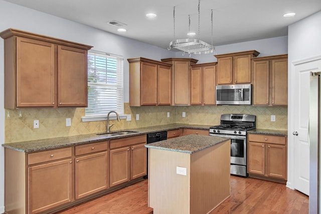123 Blackwater Way, Moncks Corner, SC 29461 - kitchen with stainless steel appliances, dark stone countertops, a kitchen island, light wood finished floors, and decorative backsplash