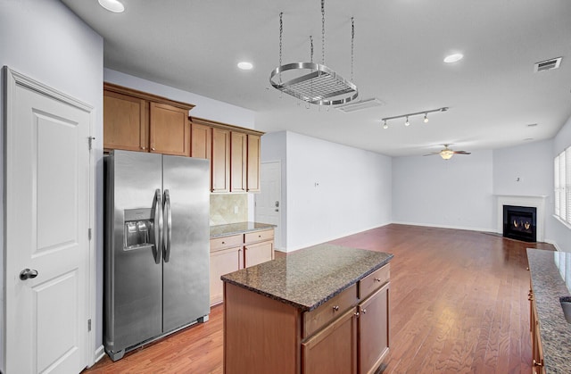 123 Blackwater Way, Moncks Corner, SC 29461 - kitchen with stainless steel refrigerator with ice dispenser, a ceiling fan, a fireplace with flush hearth, a kitchen island, and backsplash