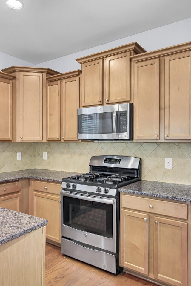 123 Blackwater Way, Moncks Corner, SC 29461 - kitchen featuring stainless steel appliances, dark stone countertops, light wood-type flooring, decorative backsplash, and light brown cabinetry