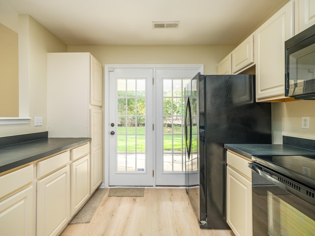 kitchen featuring black appliances, light hardwood / wood-style floors, and white cabinets