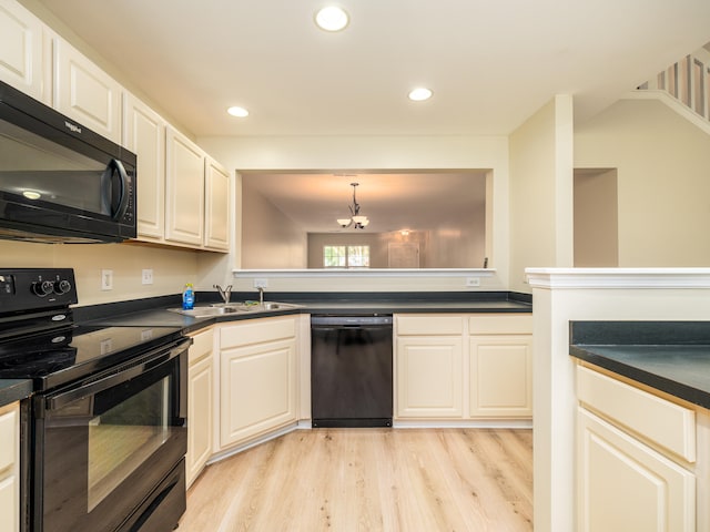 kitchen with sink, hanging light fixtures, light hardwood / wood-style floors, and black appliances