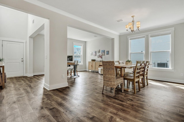 dining room featuring visible vents, dark wood finished floors, an inviting chandelier, crown molding, and baseboards