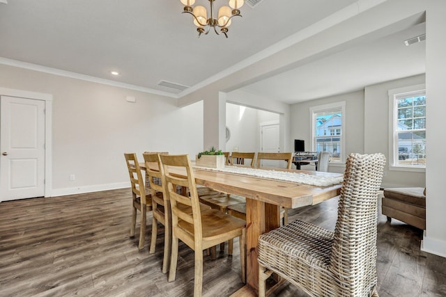 dining room with visible vents, ornamental molding, wood finished floors, an inviting chandelier, and baseboards