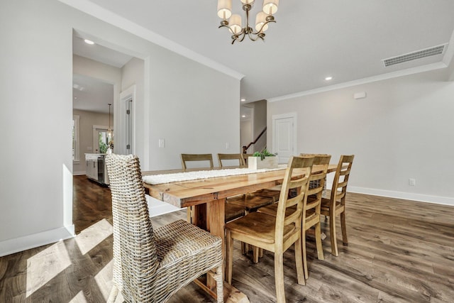 dining area with visible vents, baseboards, wood finished floors, and a chandelier