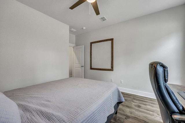 bedroom featuring ceiling fan, visible vents, baseboards, and wood finished floors