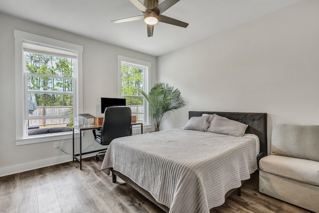 bedroom featuring a ceiling fan, baseboards, and wood finished floors