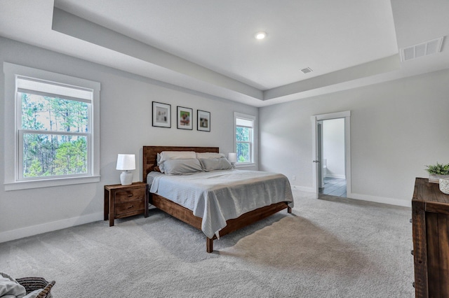 carpeted bedroom with recessed lighting, visible vents, baseboards, and a raised ceiling