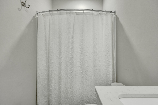 full bath featuring vanity, curtained shower, and toilet