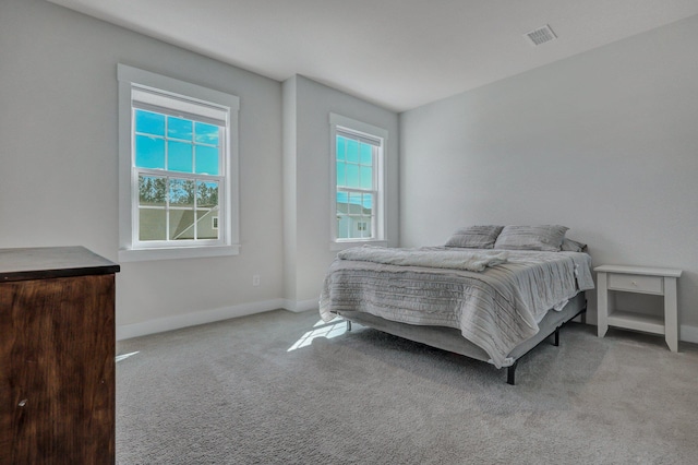 carpeted bedroom with visible vents and baseboards