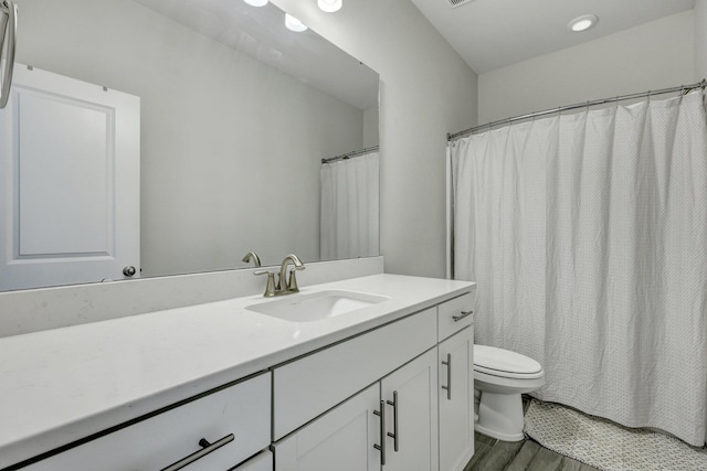 bathroom featuring toilet, vanity, and wood finished floors