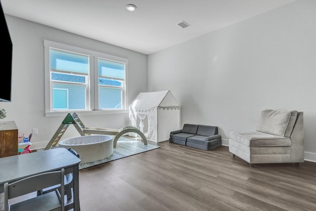 sitting room with visible vents, baseboards, and wood finished floors