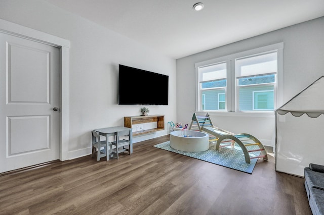 living area with baseboards and wood finished floors