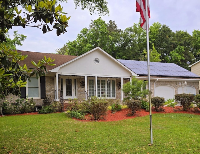 single story home with a front lawn, a porch, a garage, and solar panels