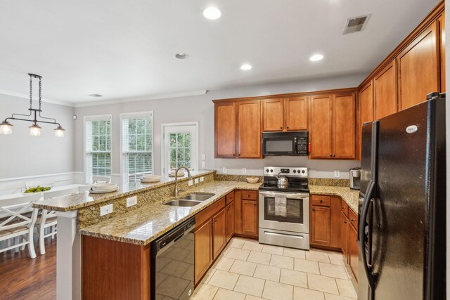 kitchen featuring a sink, brown cabinets, black appliances, and a peninsula