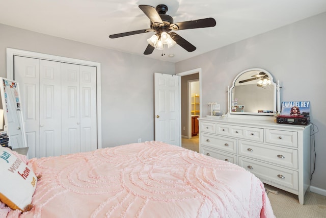 bedroom with baseboards, light colored carpet, a closet, and ceiling fan