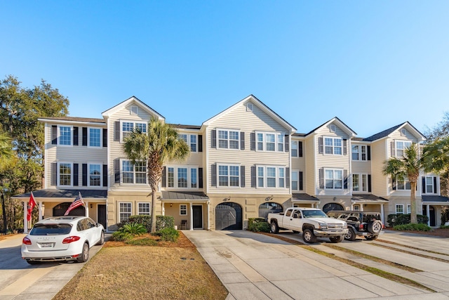 townhome / multi-family property featuring driveway and a garage