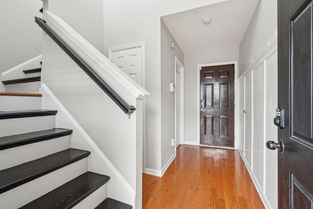 foyer with stairway, baseboards, and light wood-style flooring