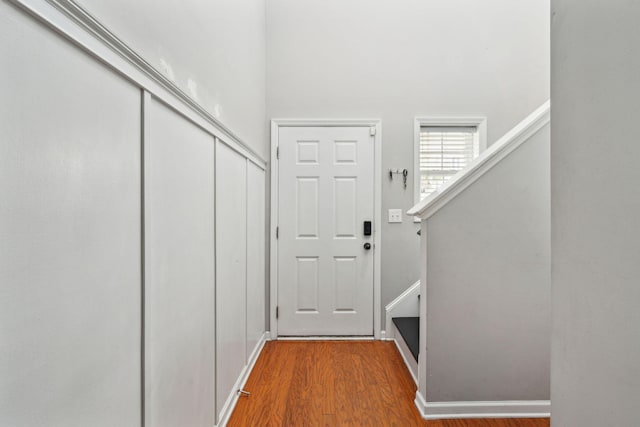 entryway featuring stairway, baseboards, and wood finished floors