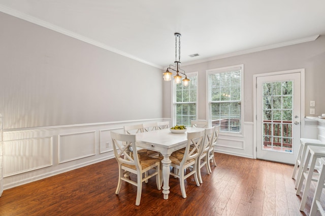 dining room featuring hardwood / wood-style flooring, ornamental molding, visible vents, and wainscoting