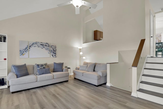 living room featuring ceiling fan, high vaulted ceiling, and light hardwood / wood-style floors