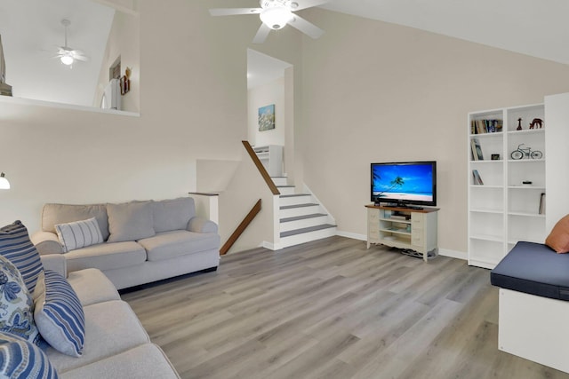 living room featuring ceiling fan, high vaulted ceiling, and light hardwood / wood-style flooring